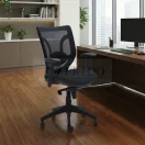 Silla ergonómica de oficina con respaldo de malla negra y apoyabrazos ajustables, ubicada frente a un escritorio de madera en una oficina moderna.