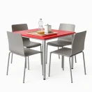 Mesa cuadrada roja, cubierta 70×70 cm y altura 72,5 cm, polipropileno y estructura metálica con pintura electrostática. Ambientada en una cafetería moderna con fondo blanco.