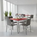Mesa cuadrada roja 70×70 cm (alto 72,5 cm) en cafetería; cubierta de polipropileno y estructura metálica con pintura electrostática.