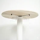 Detalle inferior mesa redonda pedestal Lua, unión de cubierta de melamina con cruceta metálica y pedestal blanco, Prido.