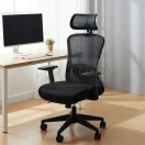 Silla de oficina ergonómica Toronto en color negro con respaldo de malla, cabezal ajustable y soporte lumbar en un ambiente de escritorio moderno.