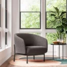 Sillón Cosmo de un cuerpo gris junto a una ventana con mesa auxiliar redonda